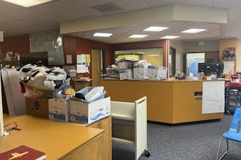 caption: As schools across the nation and state grapple with large budget deficits, a growing number of school libraries are no longer staffed — including at Concrete Elementary, where the librarian's old desk is now covered in boxes.