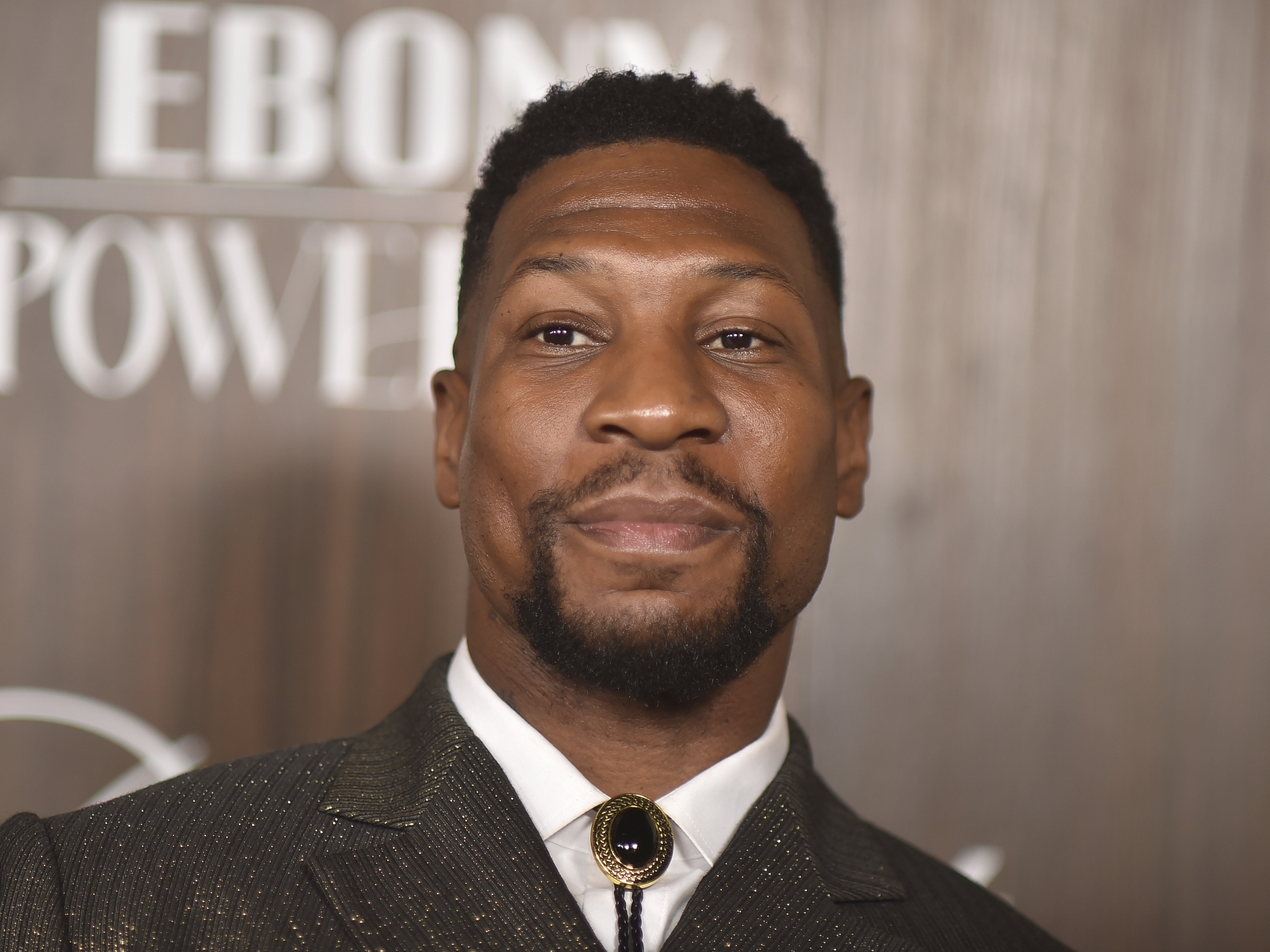 caption: Jonathan Majors arrives at the Ebony Power 100 gala on Sunday, Nov. 17.