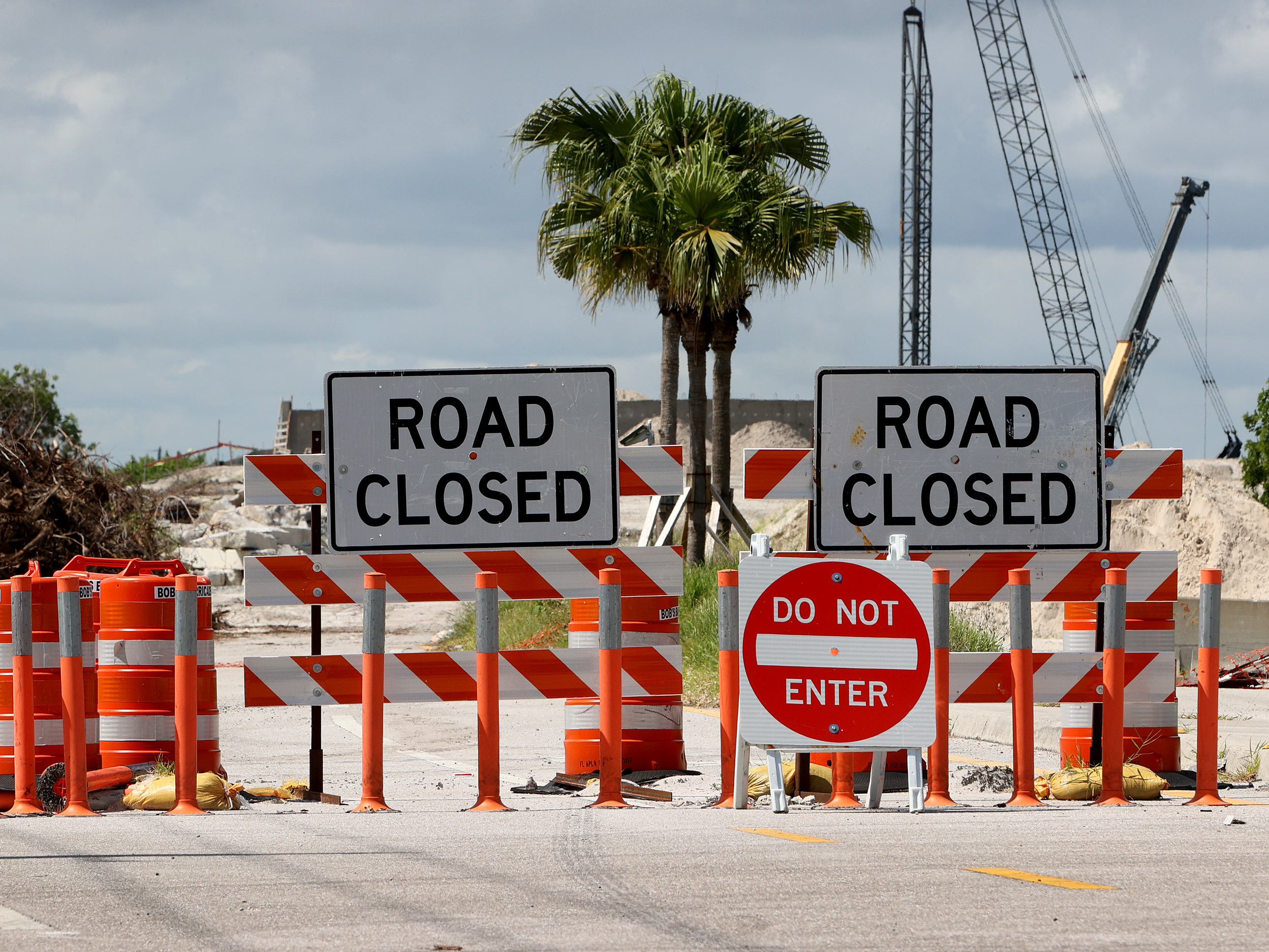 caption: Florida Gov. Ron DeSantis has approved a plan to use phosphogypsum, a radioactive waste material, in "demonstration projects." Here, signs block a roadway in Boca Raton during a construction project in 2021.
