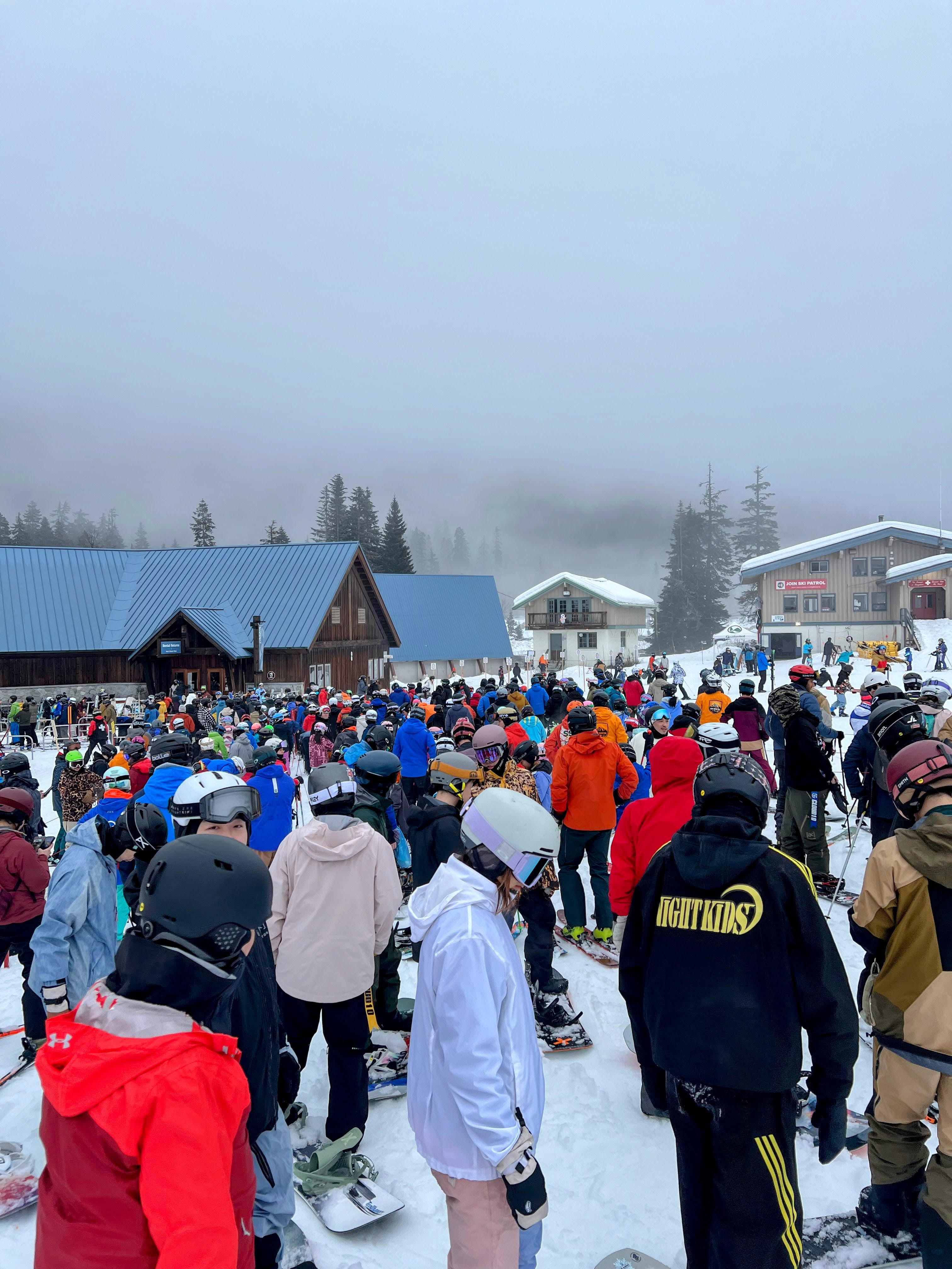 caption: Crowds gather in front of the singular lodge open at the Summit at Snoqualmie on Jan. 31, 2026.