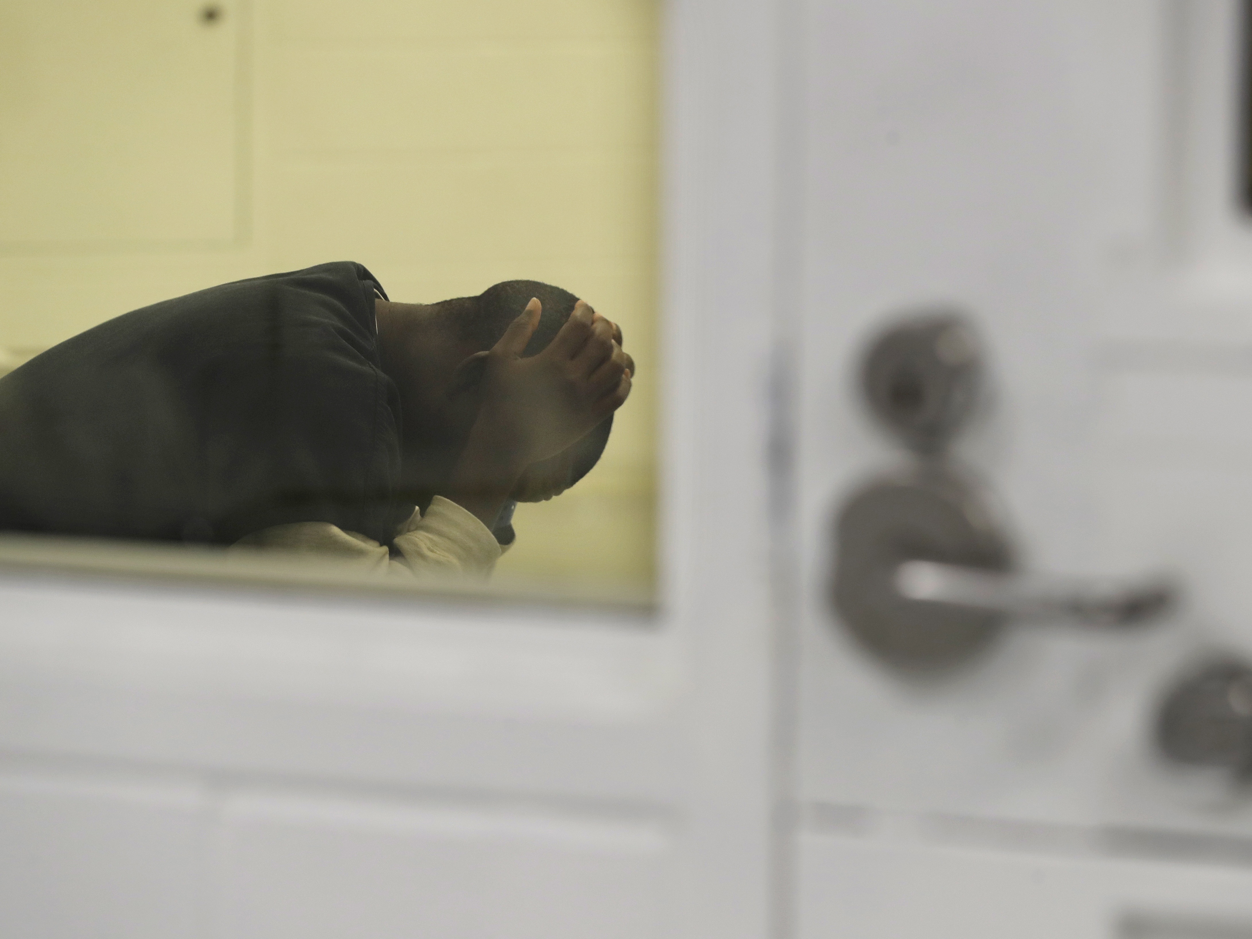 caption: A detainee waits in a holding area during a media tour at the U.S. Immigration and Customs Enforcement detention facility in Tacoma, Wash., on Sept. 10, 2019. 