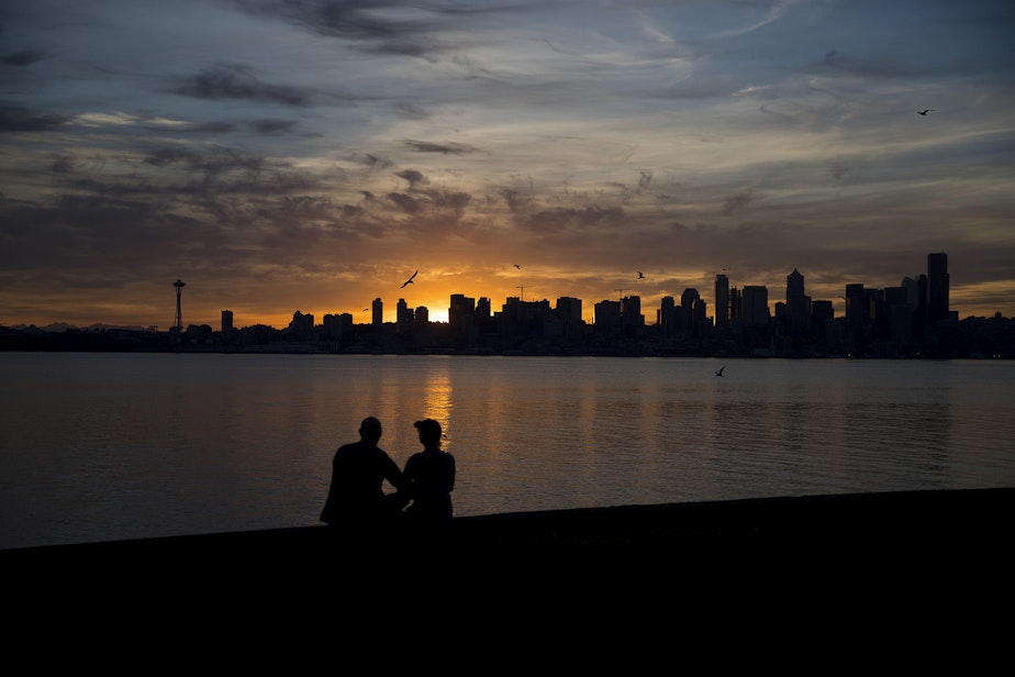 caption: David and Meg Haggerty watch the sun come up on Wednesday, June 12, 2019 at 5:14 a.m. from Alki Ave Southwest in Seattle.