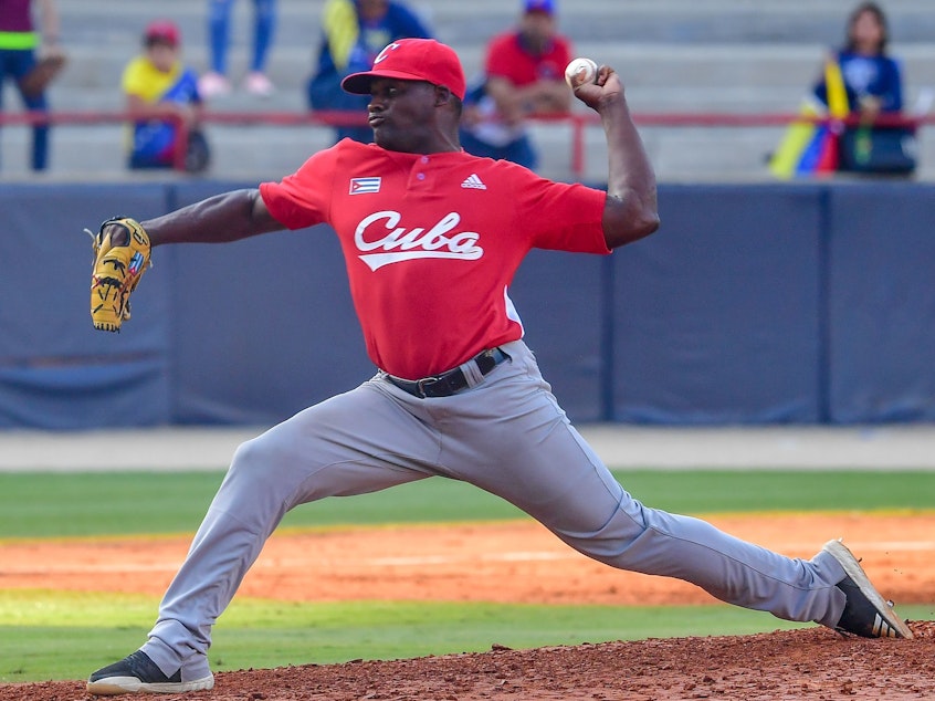 caption: Alexis Rivero of Cuba's Las Tunas Leñeros pitches during a Caribbean Series match against Venezuela's Cardenales de Lara in Panama City on Feb. 6. Major League Baseball had made a deal with Cuba's baseball federation to allow Cuban players to play in the U.S. without defecting, only to see the Trump administration subsequently block the rule.
