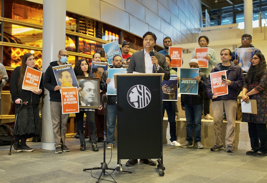 caption: Samir Khobragade explains how his family has fought against caste discrimination in India, and hopes to address it here. City Councilmember Kshama Sawant (far right) held a press conference Tuesday to announce legislation that would ban caste-based discrimination in Seattle. 