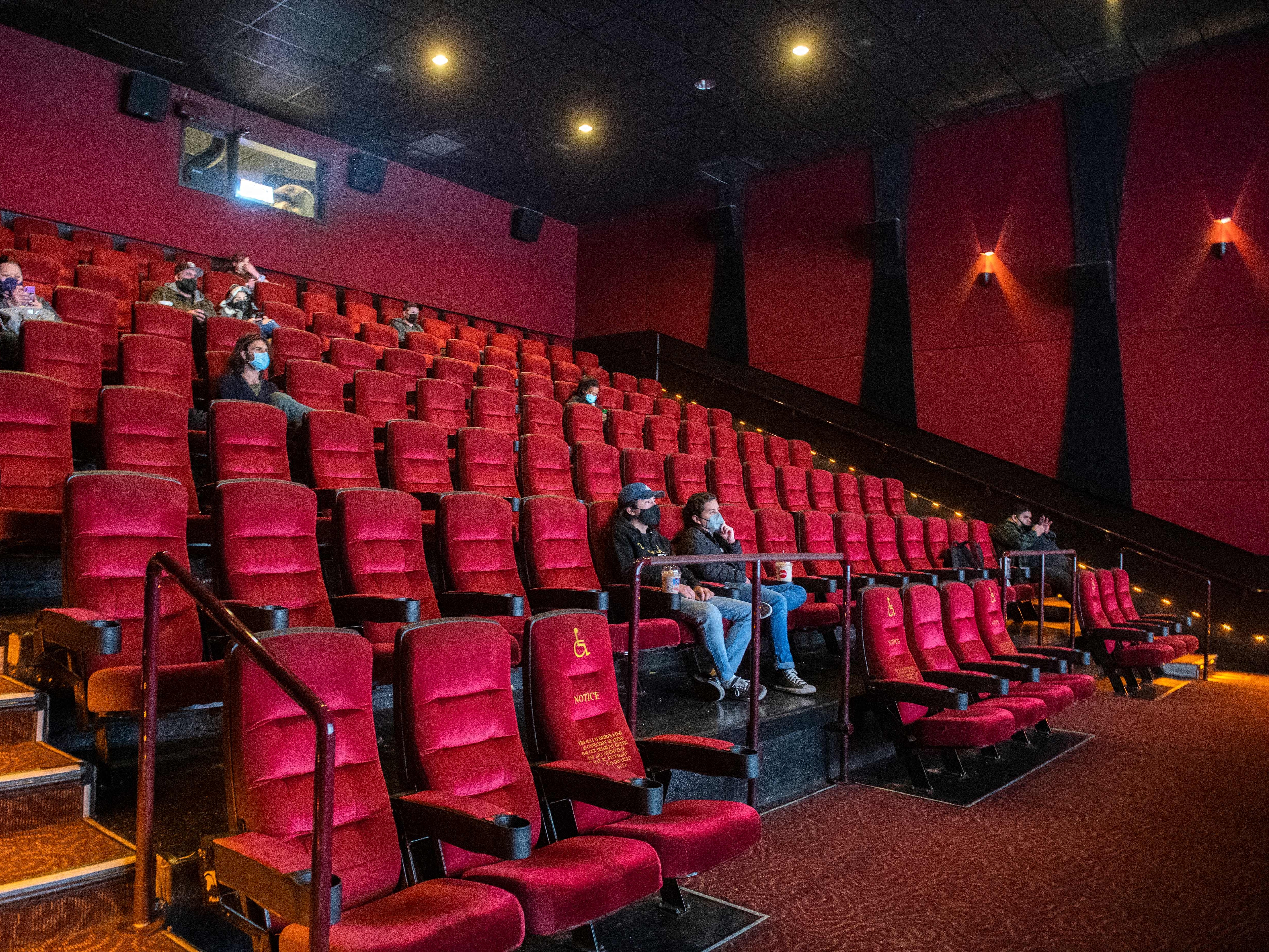 caption: Moviegoers wait for their movie to start at the AMC Burbank in Burbank, Calif. on reopening day in March 2021.