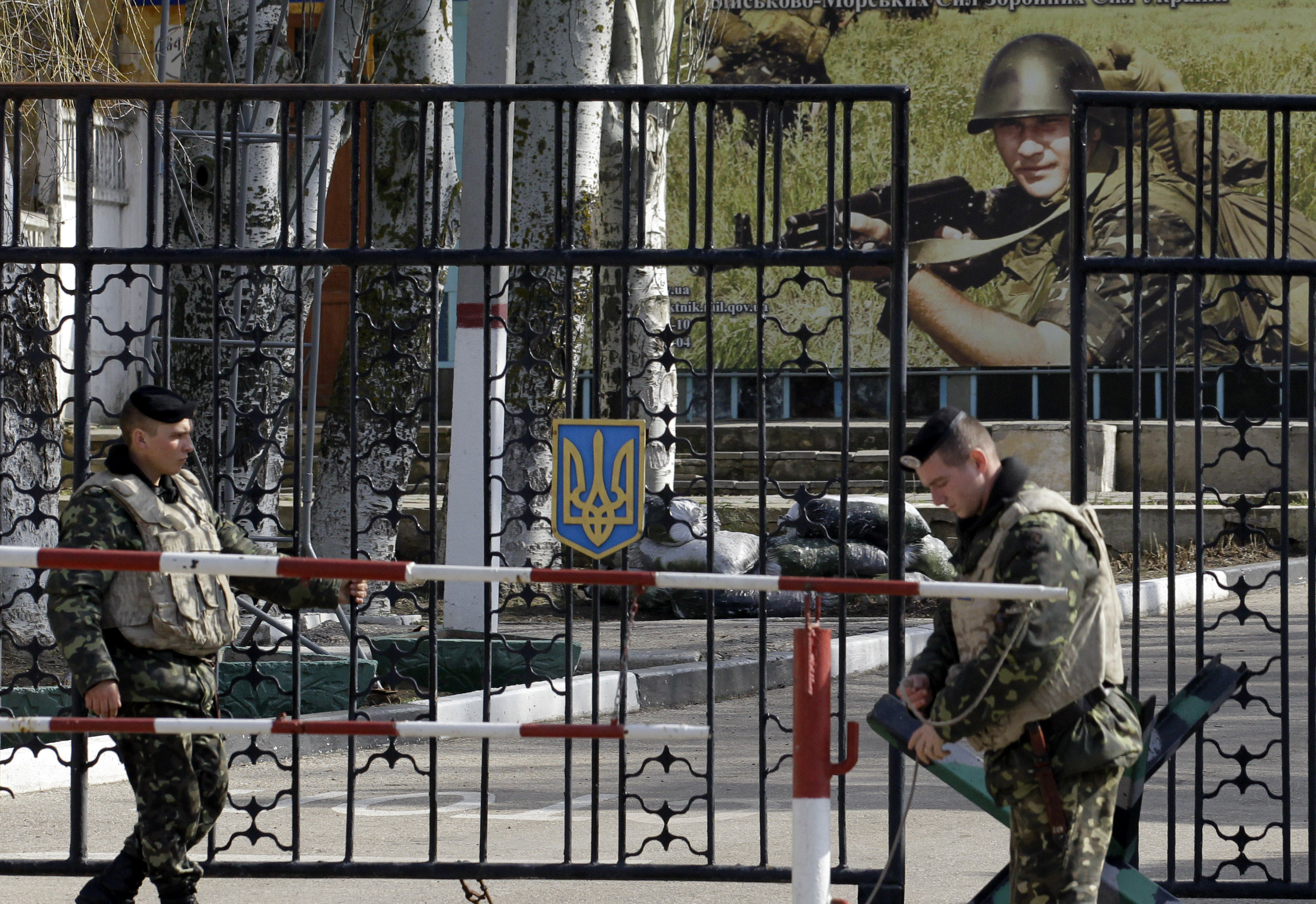 caption: Ukrainian soldiers stand guard at the gate of a military base in the port of Kerch, Ukraine, Monday, March 3, 2014. 