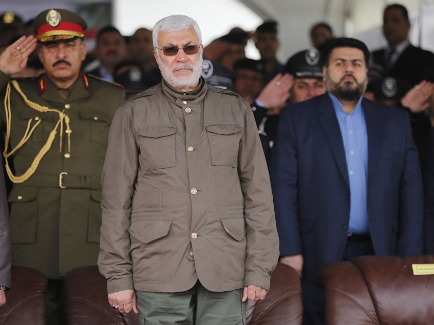 caption: In this 2016 file photo, Abu Mahdi al-Muhandis, center, attends a ceremony marking Police Day in Baghdad, Iraq. Muhandis was killed in a drone strike early Friday.