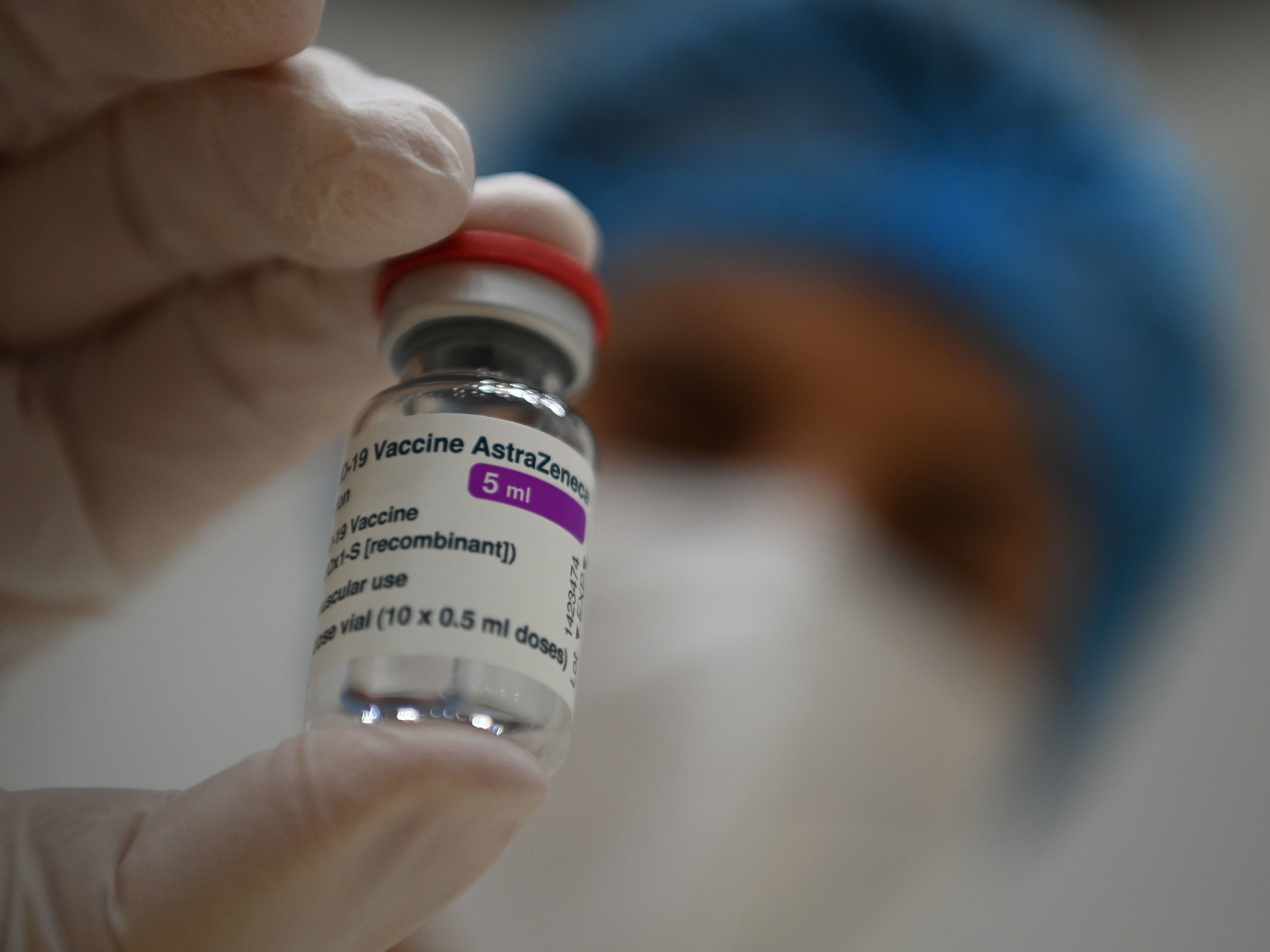 caption: "There are not yet enough vaccine doses in Europe to stop the third wave by vaccination alone," German Health Minister Jens Spahn said Friday. Here, a health care worker displays a vial of the AstraZeneca COVID-19 vaccine in Stuttgart, Germany.