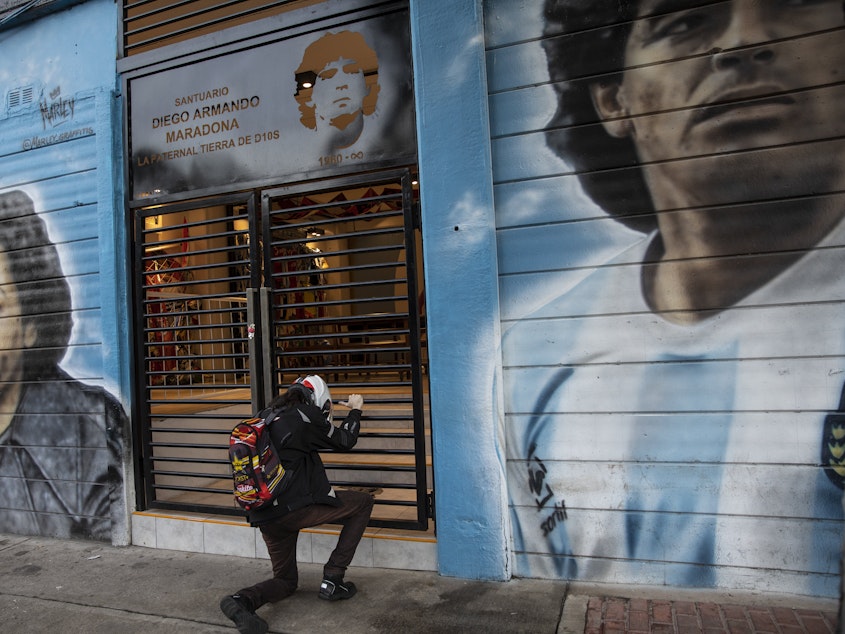 caption: A man prays in front of a sanctuary for the late soccer star Diego Maradona at Argentinos Juniors stadium in Buenos Aires, Argentina, last November.