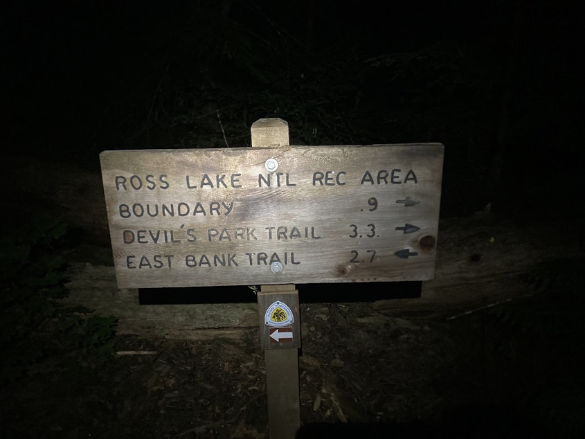 caption: A trail sign in Ross Lake National Recreation Area, east of the Sourdough fire, with the Pacific Northwest Trail logo at bottom on Aug. 11, 2023.
