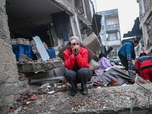 caption: An earthquake survivor reacts as rescuers look for victims and other survivors in Hatay, the day after a 7.8-magnitude earthquake struck the country's southeast on February 7, 2023.