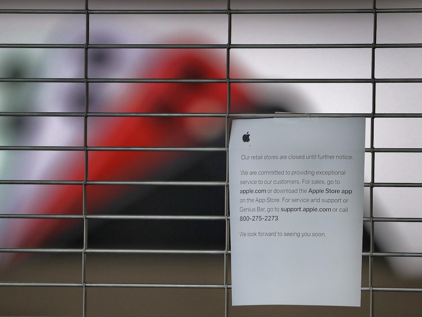 caption: A sign on a shuttered Apple Store at the International Plaza shopping center in Tampa, Fla. The location has been closed because of the coronavirus and is scheduled to reopen Thursday.