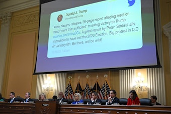caption: A tweet by former President Donald Trump appears on screen during a House Select Committee hearing to investigate the Jan. 6 attack on the U.S. Capitol. Court documents reveal this tweet drew rioters to Washington, D.C., that day.