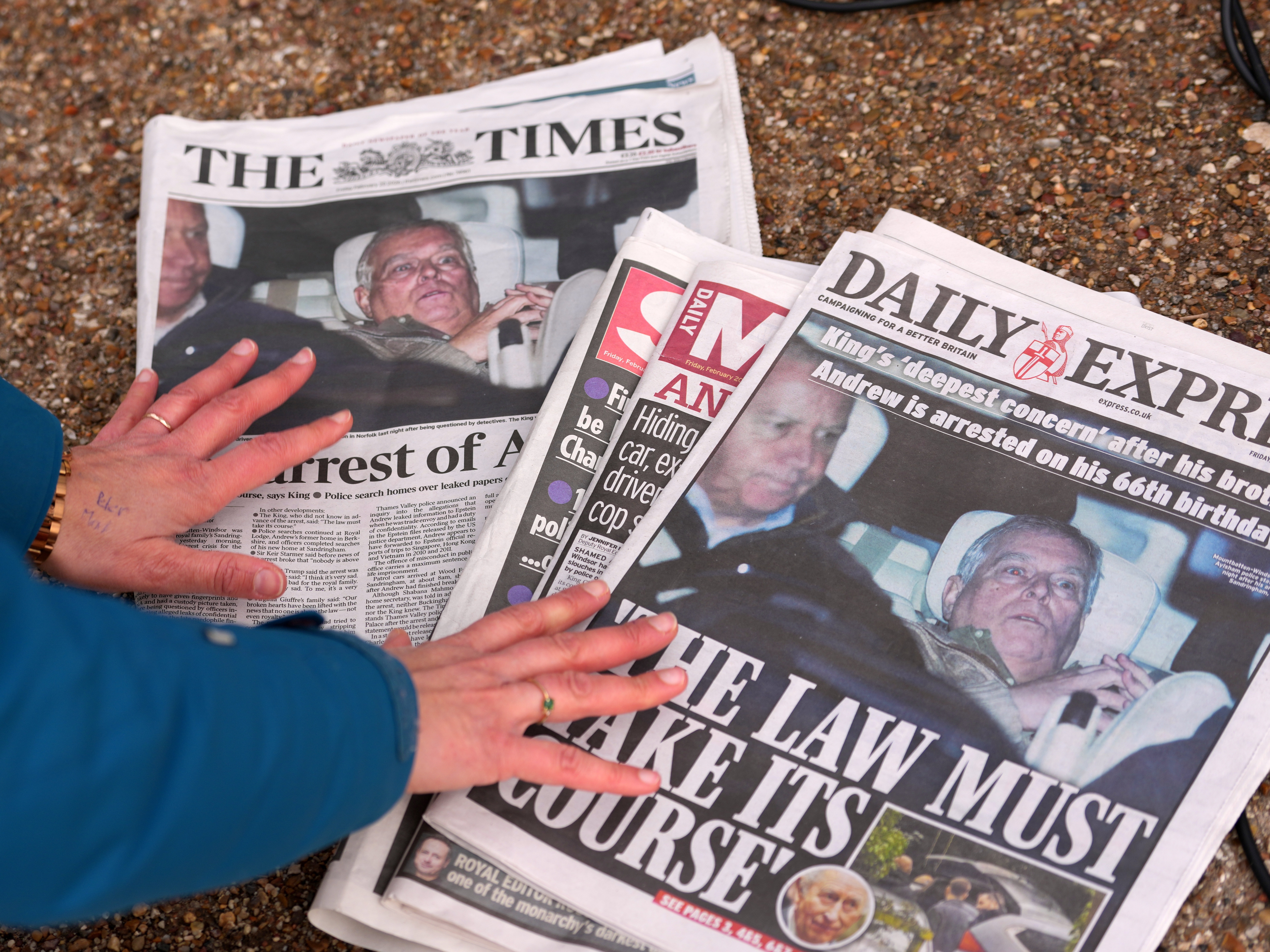 caption: A journalist looks at Friday's newspaper front pages in London after Andrew Mountbatten-Windsor was arrested and held for hours by British police on suspicion of misconduct in public office related to his links to Jeffrey Epstein.