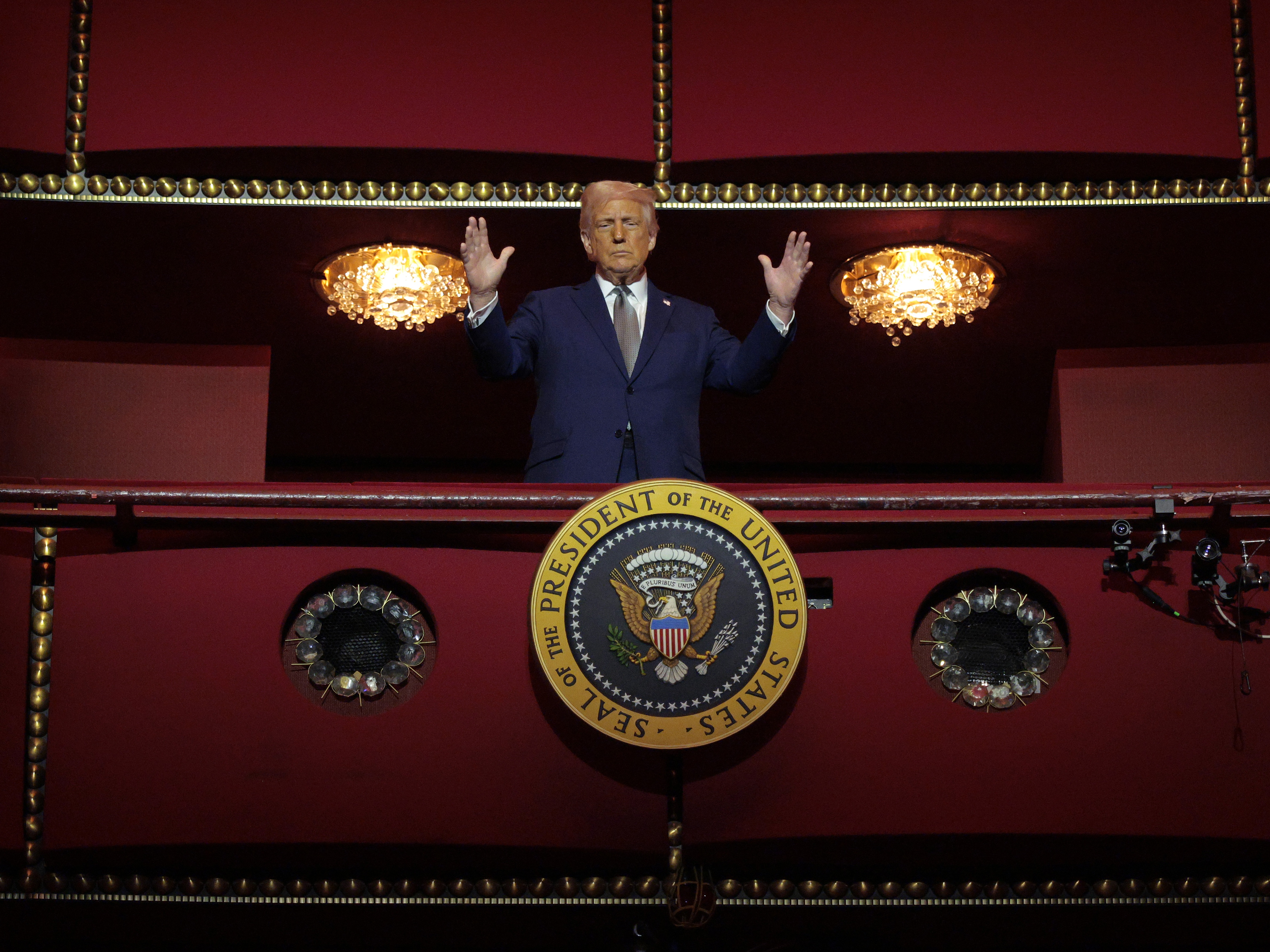 caption: President Donald Trump looks down from the Presidential Box in the Opera House at the John F. Kennedy Center for the Performing Arts on March 17, 2025 in Washington, D.C.