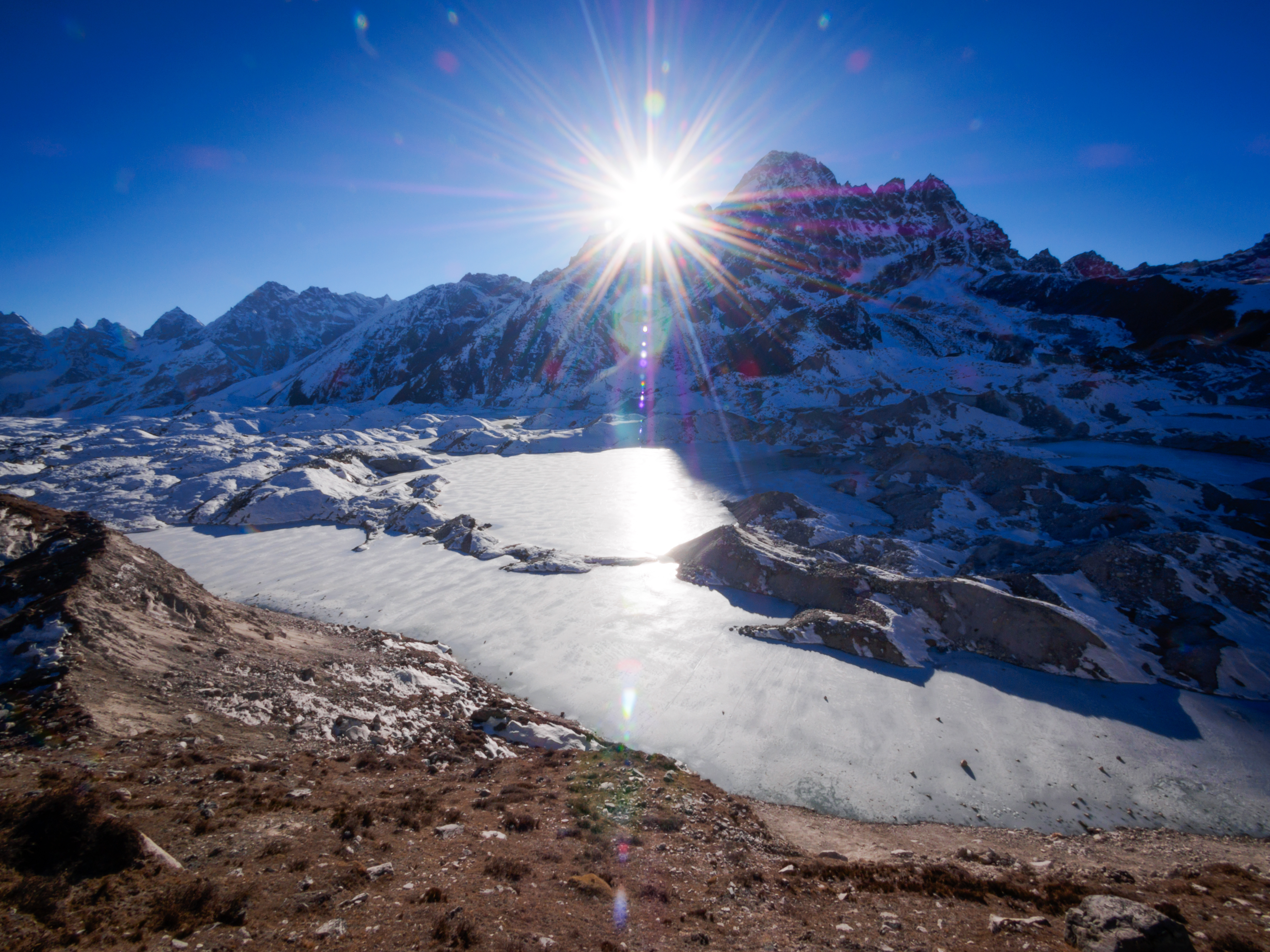 caption: The Ngozumpa Glacier in the Himalayas of Nepal, filling the valley in the foreground, now contains meltwater pools.