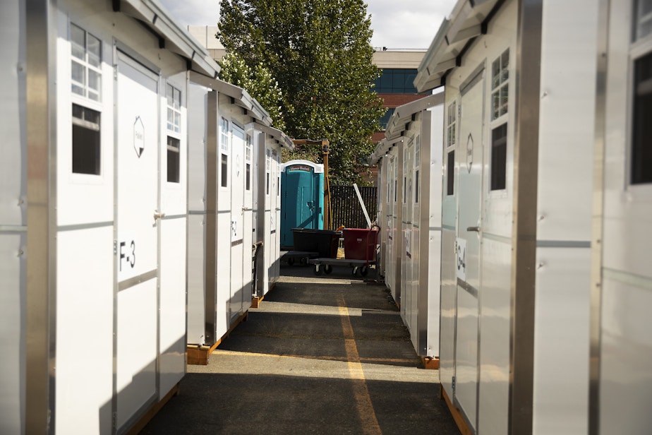 caption: Pallet shelters are lined up along Elliott Avenue on Monday, July 17, 2023, at the Bridge shelter in Seattle. 
