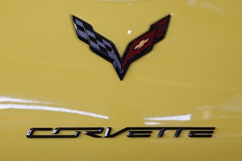 caption: The logo on the rear of a 2016 Corvette is on display at the Pittsburgh International Auto Show in 2016. General Motors says it will be offering an electrified Corvette as early as next year.