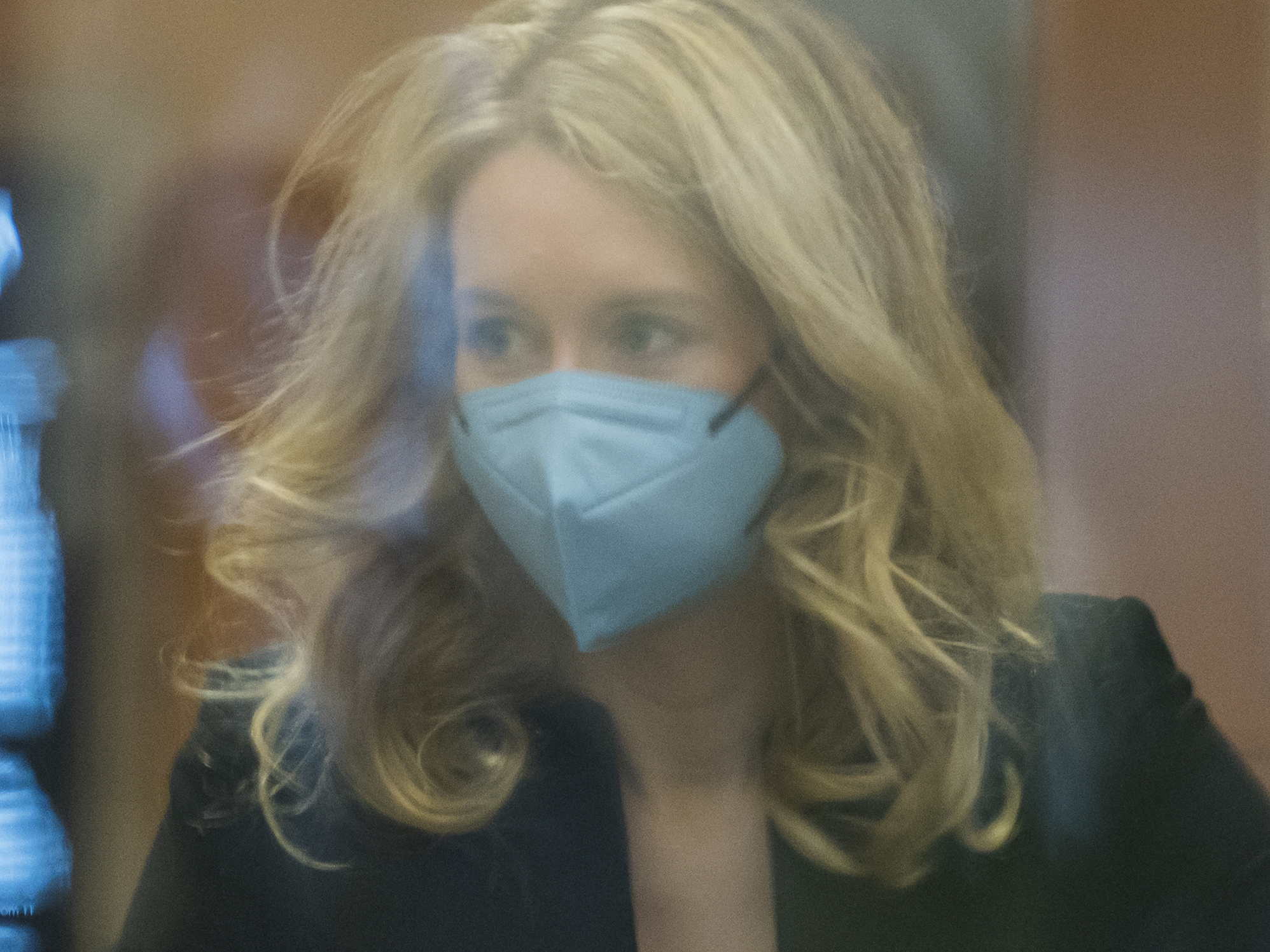 caption: Elizabeth Holmes walks into federal court in San Jose, Calif., on Monday. Holmes is accused of duping elite financial backers, customers and patients into believing that her startup was about to revolutionize medicine.
