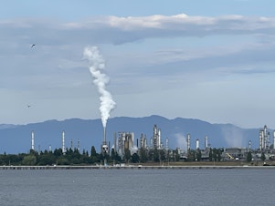 caption: Steam and invisible, heat-trapping carbon dioxide billow from the Marathon Petroleum Corporation refinery in Anacortes, Washington, in June 2023.