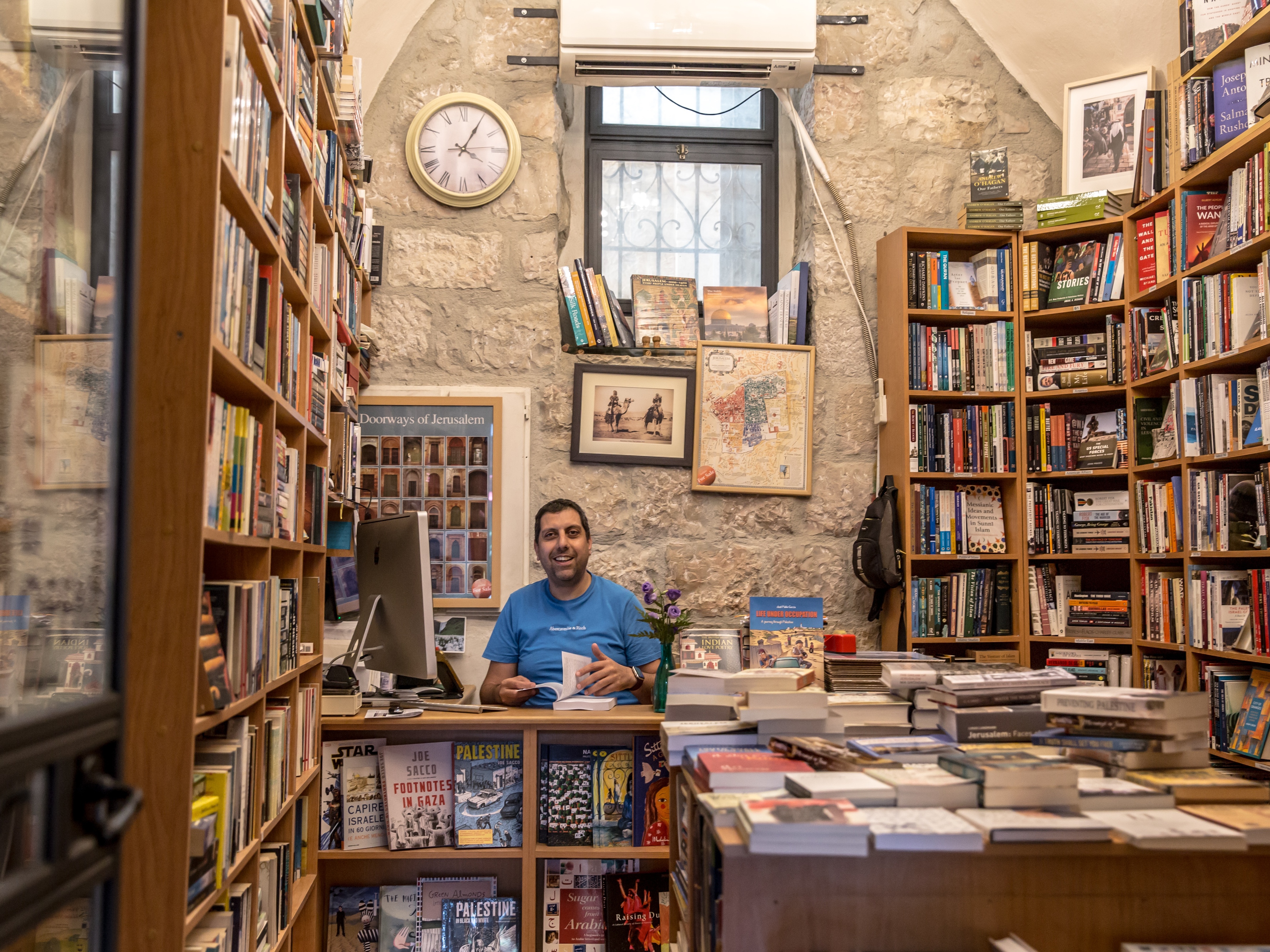 caption: Mahmoud Muna inside a branch of the Educational Bookshop chain in East Jerusalem in July 2024.