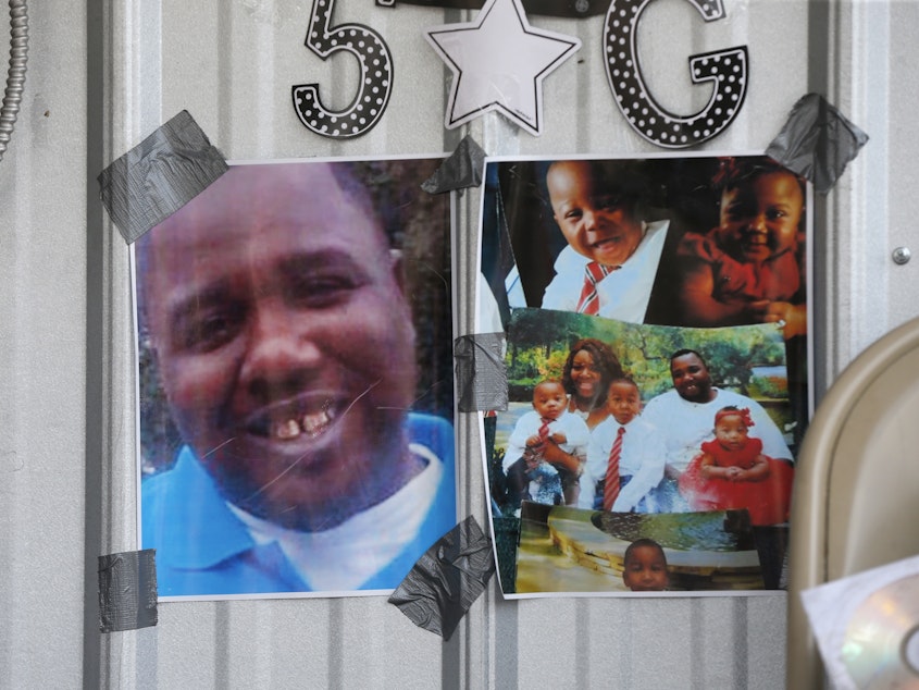 caption: In this July 6, 2016 file photo, photos of Alton Sterling are taped to a makeshift memorial outside the Triple S convenience store in Baton Rouge, La. Sterling, was shot and killed outside the store by Baton Rouge police.