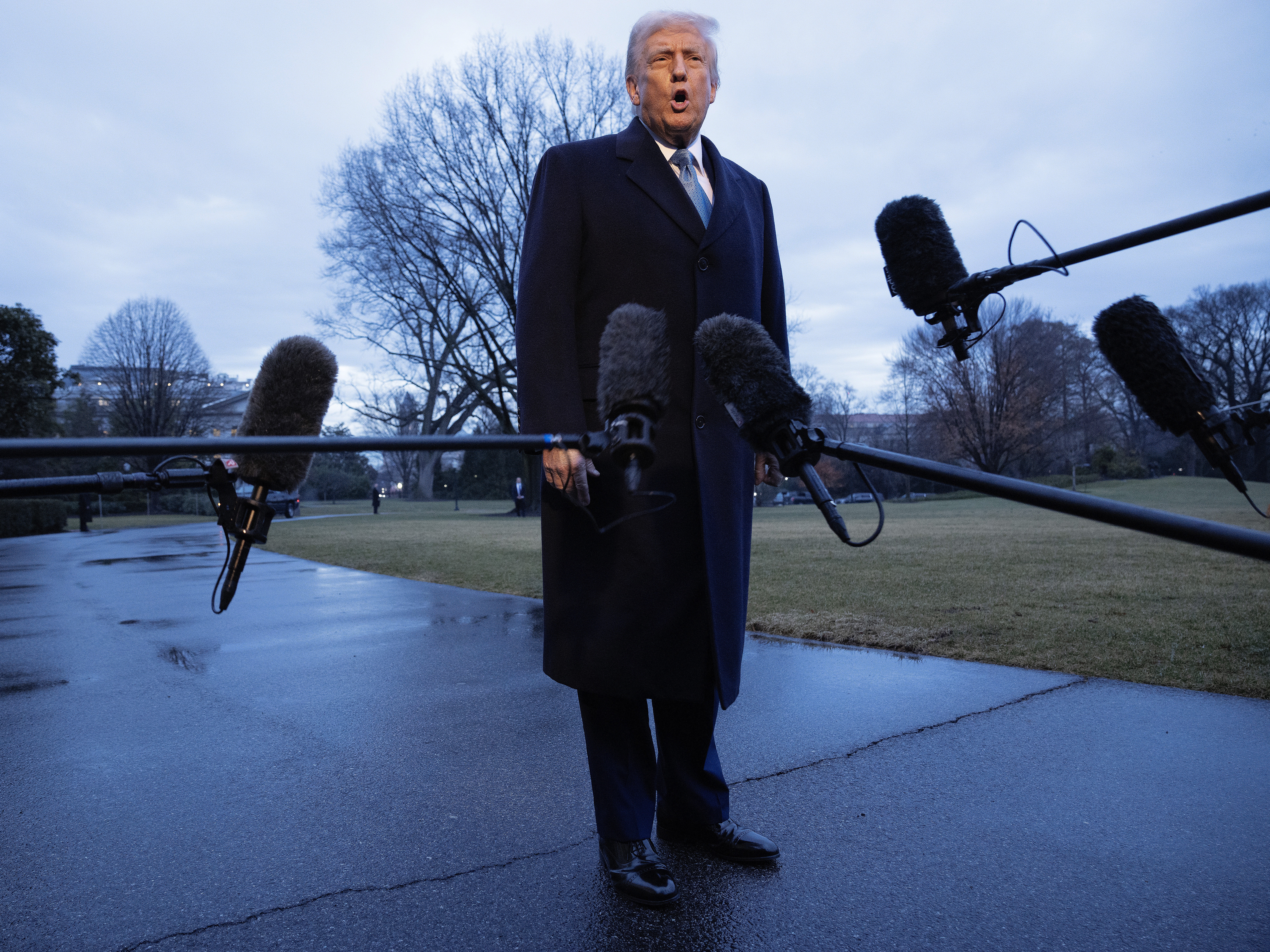 caption: President Trump speaks briefly to the press as he departs the White House on Friday for his Mar-a-Lago Club in Palm Beach, Fla.