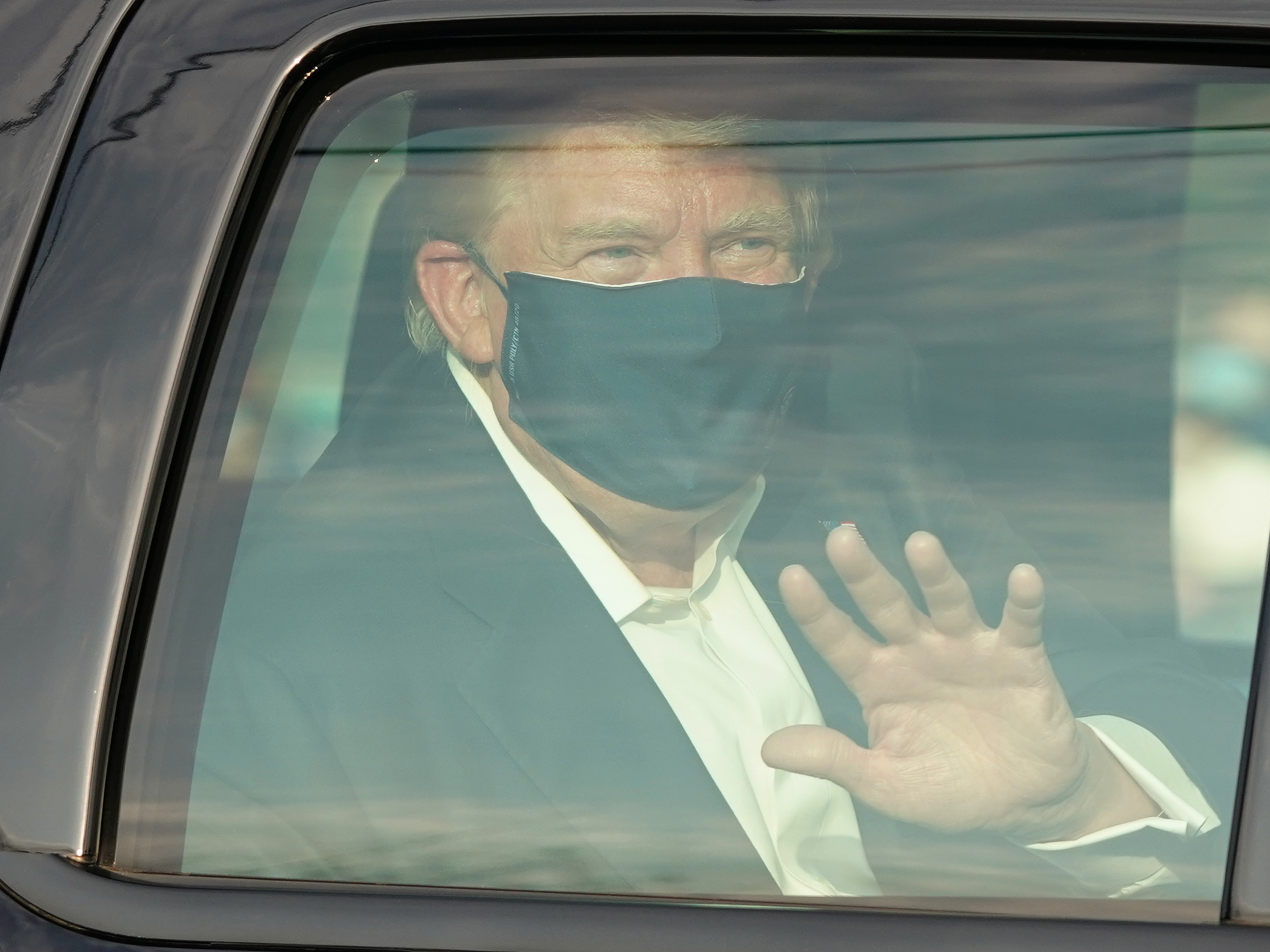 caption: President Trump waves to supporters outside of Walter Reed National Military Medical Center in Bethesda, Md., on Sunday.