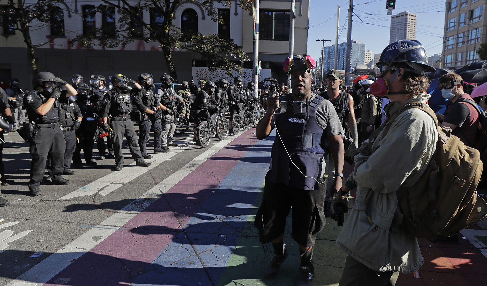 caption: Omari Salisbury, center, livestreams police and protest activity, Saturday, July 25, 2020, during a Black Lives Matter protest near the Seattle Police East Precinct headquarters. Salisbury reports for Converge Media and has been a constant presence at Black Lives Matter protests in Seattle. 