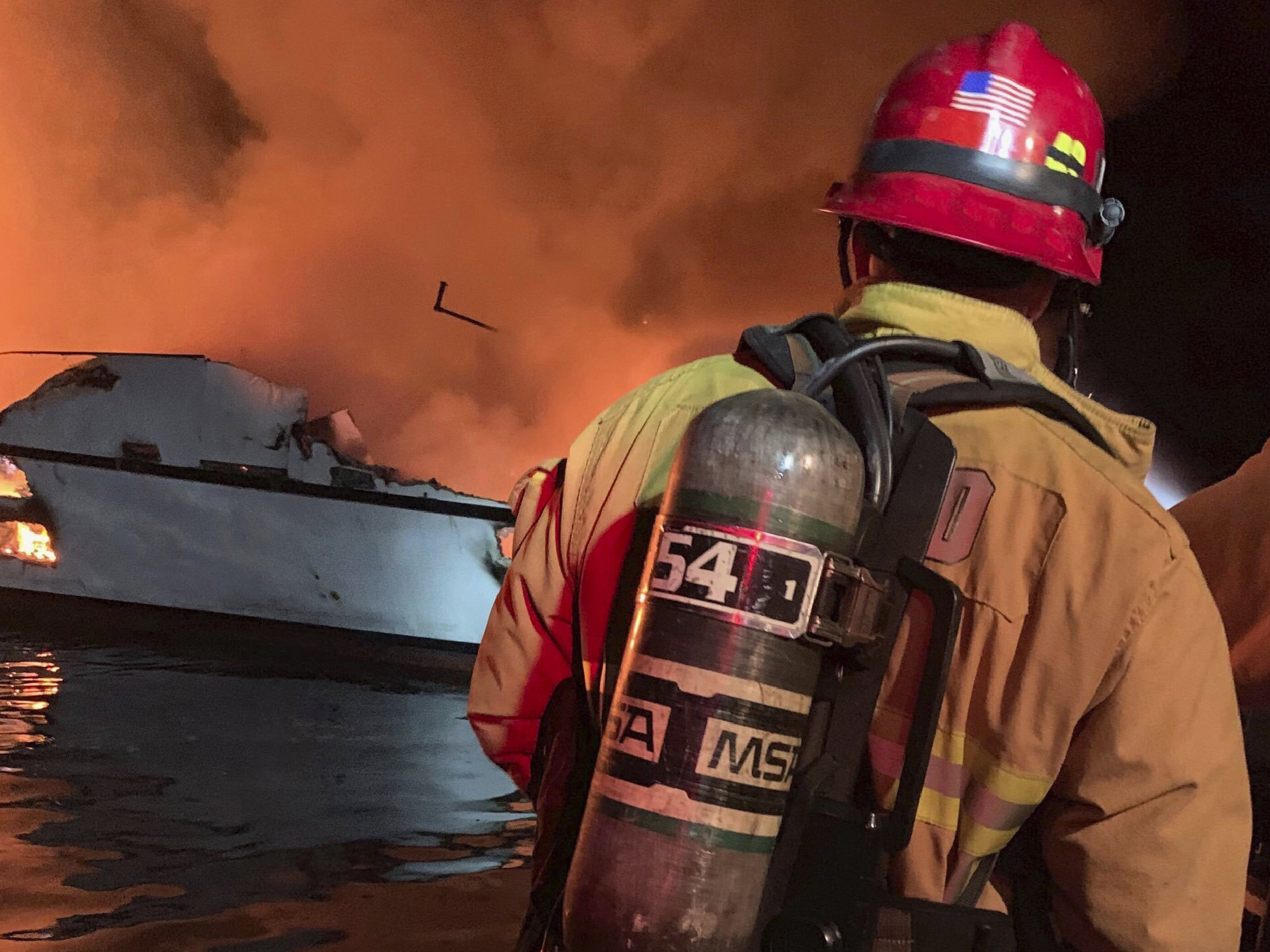 caption: Firefighters respond to a boat fire off the coast of Southern California on Monday. The U.S. Coast Guard said it launched several boats to help more than two dozen people "in distress."