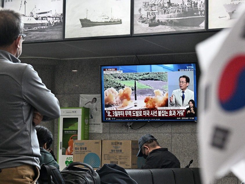 caption: Visitors watch a news broadcast showing file footage of a North Korean missile test at the ferry terminal of South Korea's eastern island of Ulleungdo, in the East Sea, also known as the Sea of Japan, on Thursday.