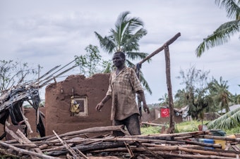 caption: A man stands in his wrecked home in Macomia, Mozambique, after Cyclone Kenneth in April. It was the second intense cyclone to strike the country in six weeks.