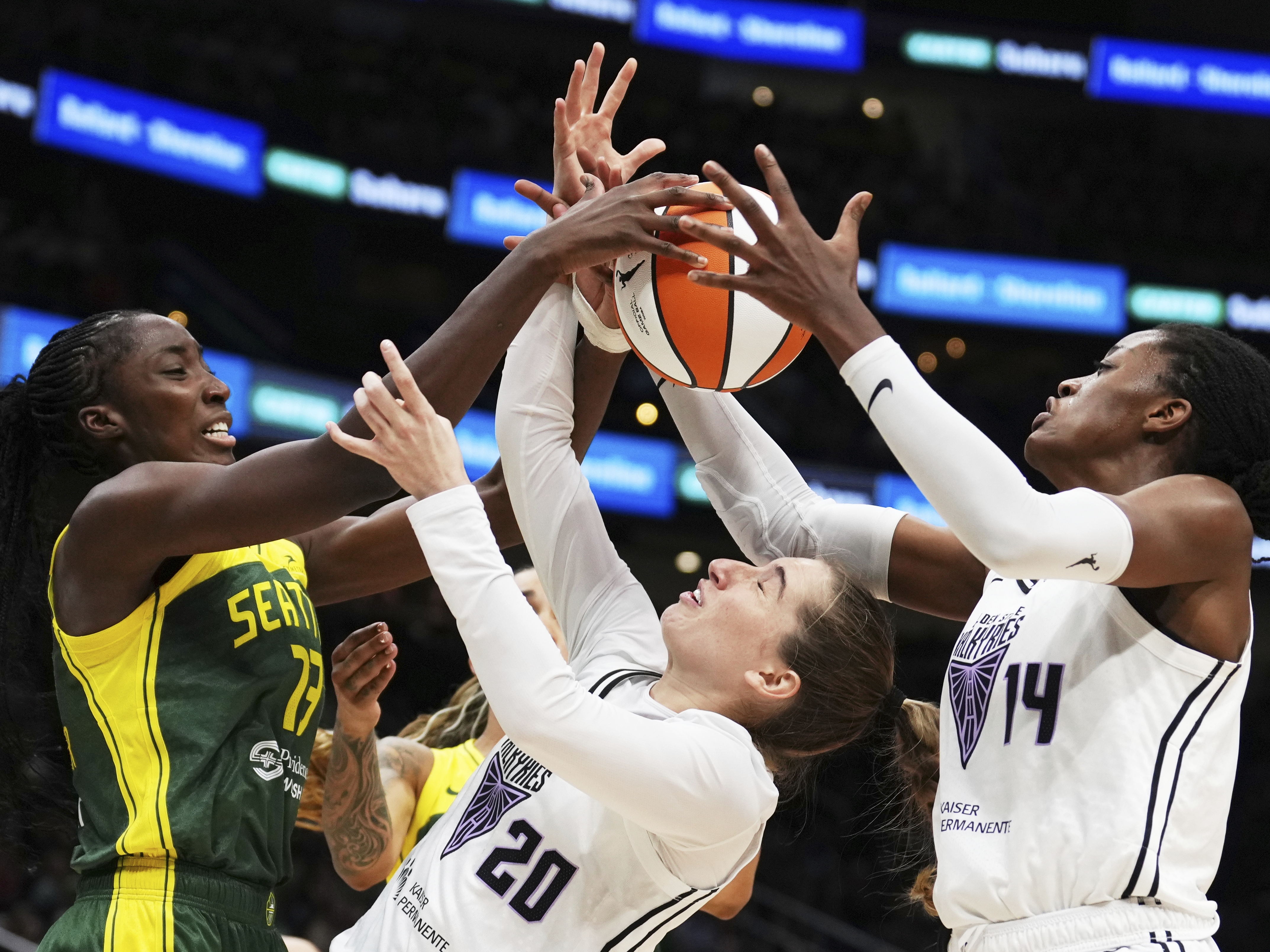caption: Golden State Valkyries guard Kate Martin (20) struggles to maintain possession against Seattle Storm forward Ezi Magbegor (left) as Valkyries center Temi Fagbenle (14) reaches for the ball during the second half of a WNBA game Wednesday in Seattle. The Valkyries debuted this season as the league's 13th team.