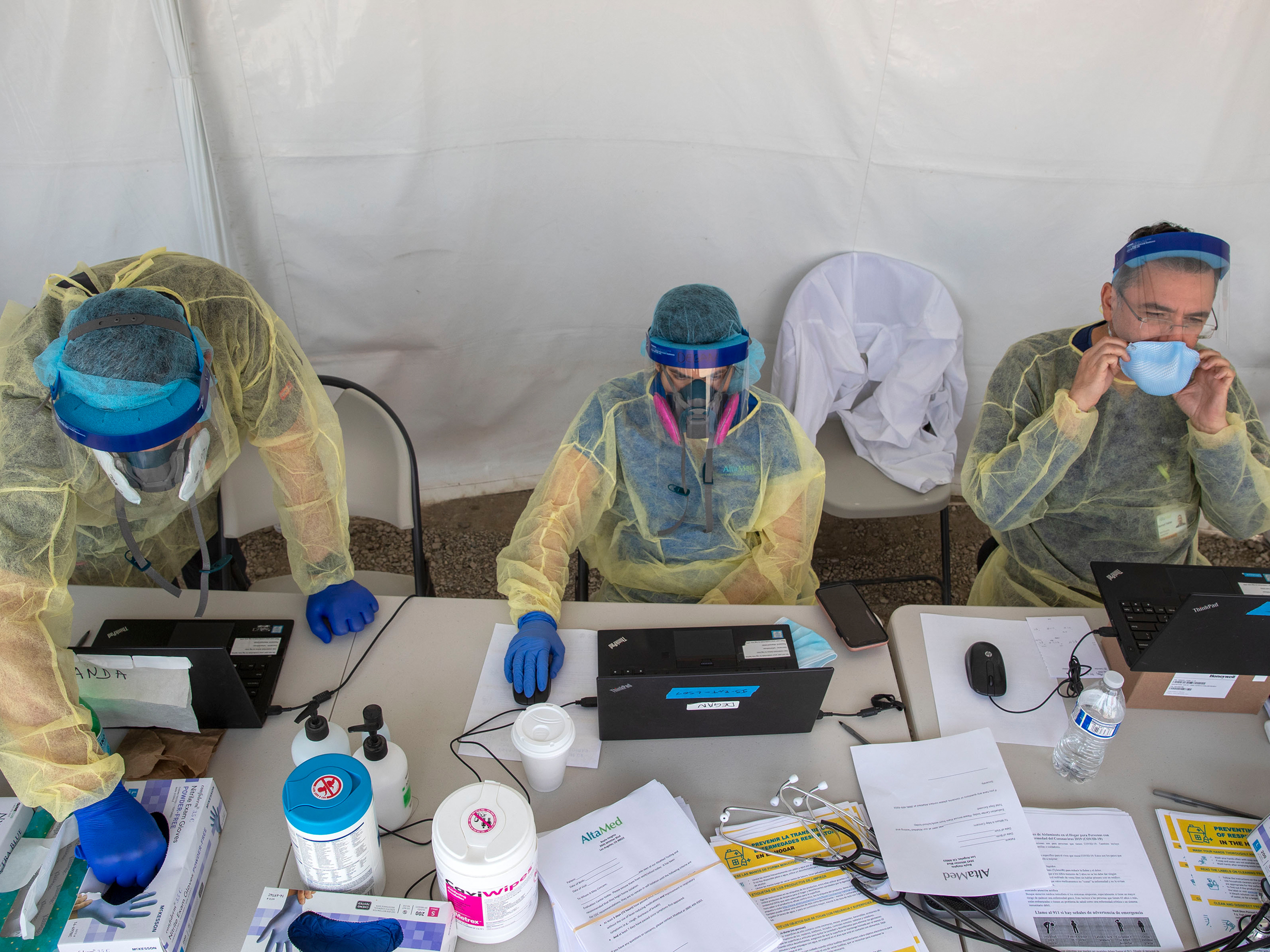 caption: A COVID-19 testing operation stays busy in Boyle Heights, Calif. Daily case counts overall may be on the low side because access to testing is limited in some parts of the world.