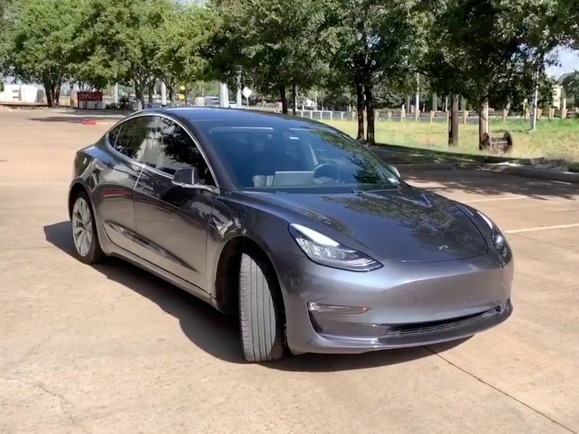 caption: A Tesla 3 model is remotely driven with the company's phone app in Austin, Texas, in this still image taken from social media video.