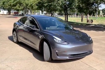 caption: A Tesla 3 model is remotely driven with the company's phone app in Austin, Texas, in this still image taken from social media video.