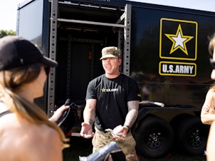 caption: Staff Sgt. Joshua Spearman talks to fairgoers at the Army recruitment tent at the Minnesota State Fair in Falcon Heights, Minn., on August 31.