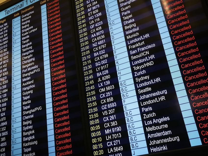 caption: An information board shows canceled flights at Hong Kong's international airport.