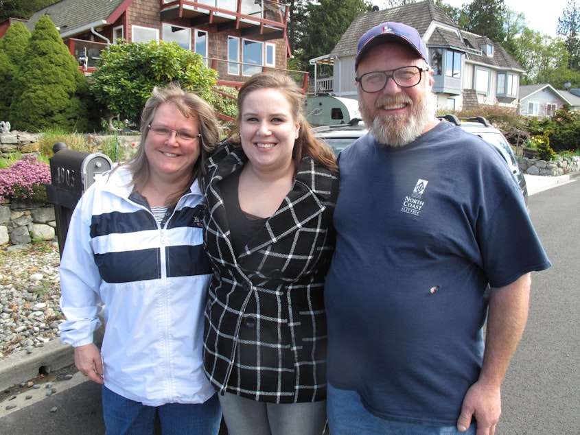 caption: Justina Bauthues (center) poses for a photo with her parents, Lisa and Tom Hilton.