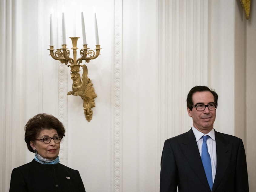 caption: Jovita Carranza, administrator of the U.S. Small Business Administration, and Treasury Secretary Steven Mnuchin attend a Paycheck Protection Program event at the White House on Tuesday.