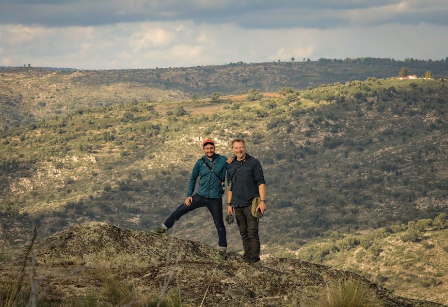 caption: Host Chris Morgan poses with Pedro Prata, Director of Rewild Portugal, with the Coa River Valley behind them. 