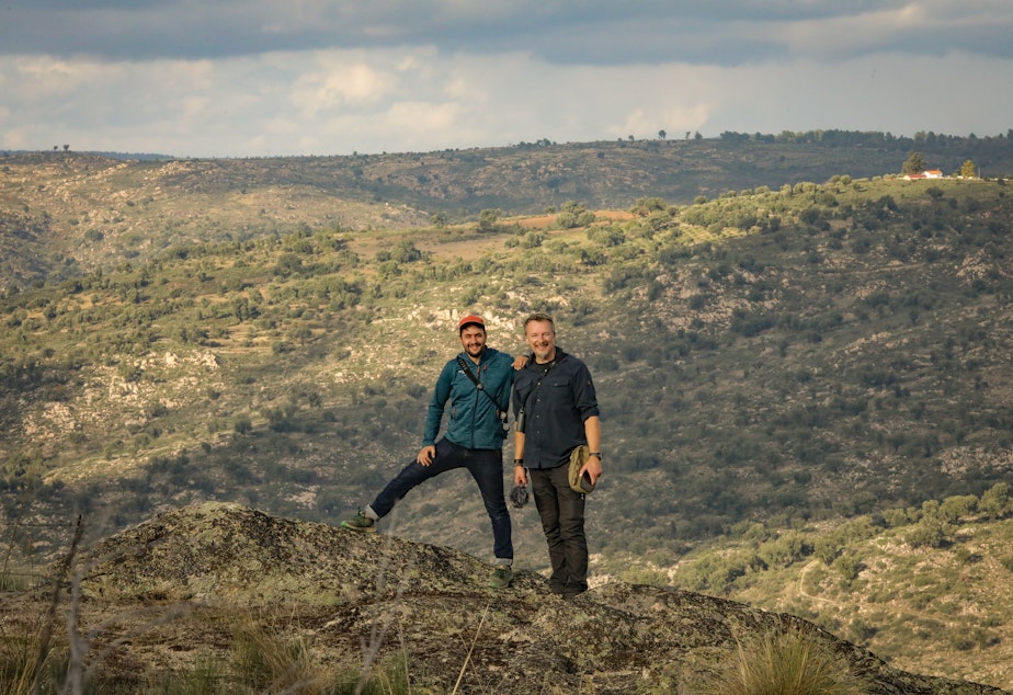 caption: Host Chris Morgan poses with Pedro Prata, Director of Rewild Portugal, with the Coa River Valley behind them.