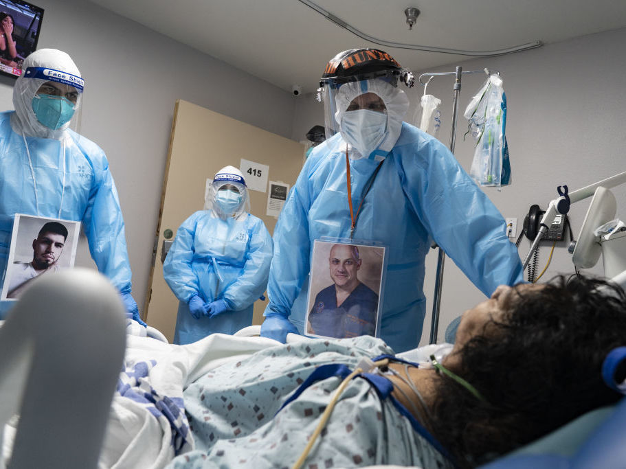 caption: Medical staff members check on a patient at the COVID-19 ICU in United Memorial Medical Center in Houston, Texas. Cases and hospitalizations rose dramatically in the U.S. this week.