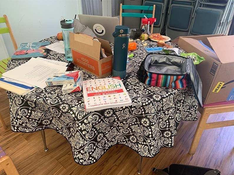 caption: Sacramento Area Congregations Together (Sac ACT) is providing English workbooks so the migrants can learn the language. The group also gives out quarters so they can do laundry.