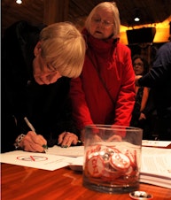 caption: Residents sign a petition against the special tax, which opponents say could cost residents tens of thousands of dollars apiece. 