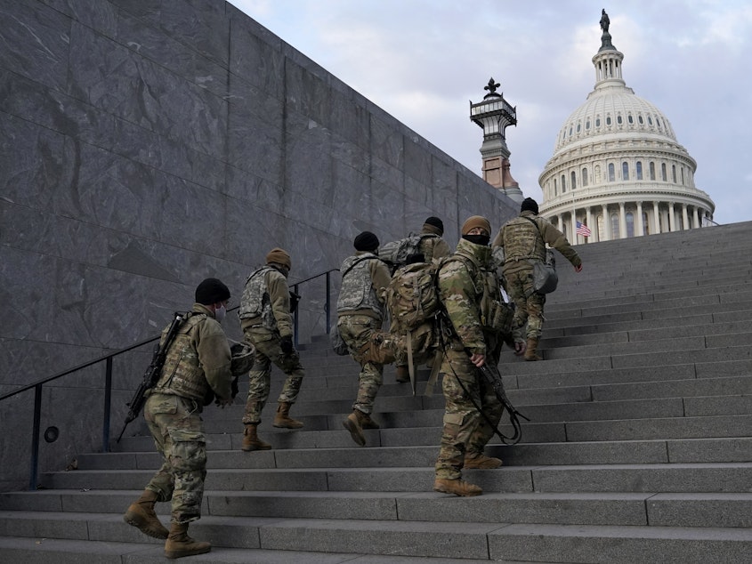caption: National Guard members take a staircase toward the U.S. Capitol building before a rehearsal for President-elect Joe Biden's Inauguration in Washington on Jan. 18, 2021. Experts in constitutional law and the military say the Insurrection Act gives presidents tremendous power with few restraints.