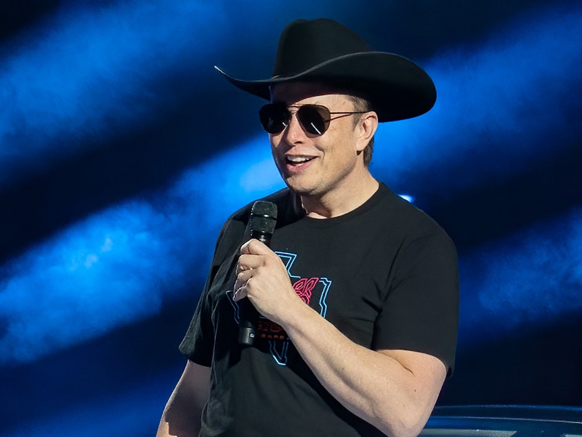 caption: Tesla CEO Elon Musk speaks at the Tesla Giga Texas manufacturing "Cyber Rodeo" grand opening party on April 7, 2022 in Austin, Texas.