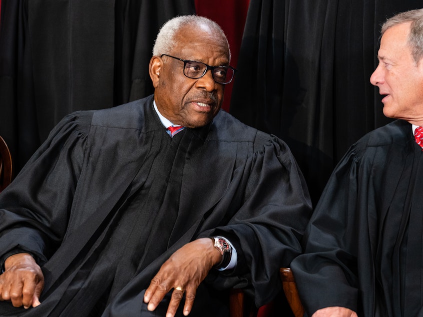 caption: Associate Justice Clarence Thomas, left, talks to Chief Justice John Roberts during the formal group photograph at the Supreme Court in Washington, D.C., on Oct. 7, 2022.