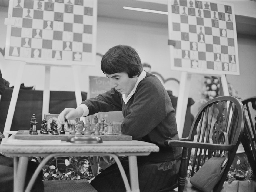 caption: Georgian chess champion Nona Gaprindashvili plays at the International Chess Congress in London on Dec. 30, 1964. She is suing Netflix for defamation and invasion of privacy over its series <em>The Queen's Gambit.</em>