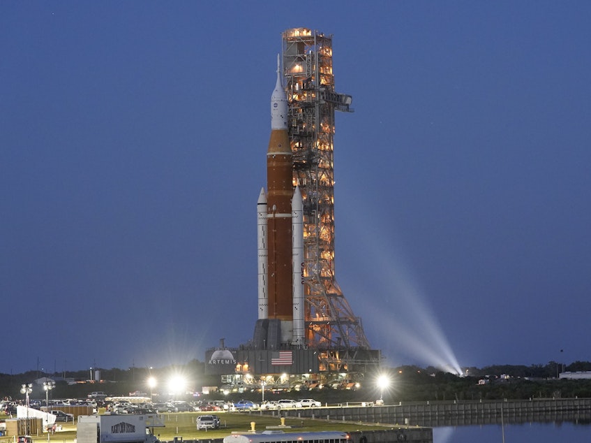caption: The NASA Artemis 1 rocket with the Orion spacecraft aboard moves slowly on an 11 hour journey to a launch pad at the Kennedy Space Center in Cape Canaveral, Fla., on Thursday, March 17, 2022.